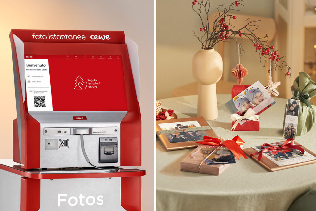Stazione fotografica CEWE con dettagli rossi, foto e idee regalo su un tavolo decorato.